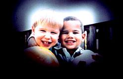 Image of two boys smiling but the outside of the image is obscured by black, representing effects of glaucoma.