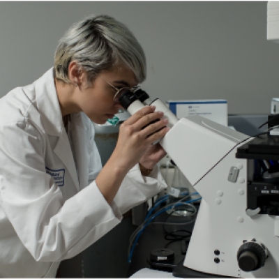 female scientist looking through microscope