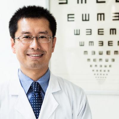 Eye doctor in front of eye chart.