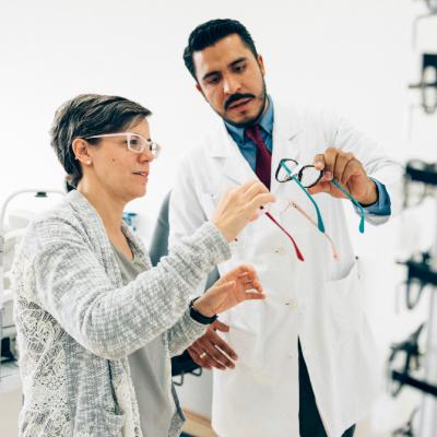 Hispanic woman picking out glasses at the eye doctor