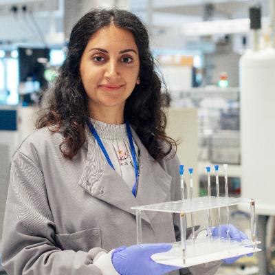 Woman scientist with scientific tubes in rack