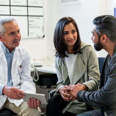 A doctor chatting with two patients 