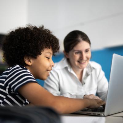 Un científico ayuda a un niño a ver a través de un microscopio.
