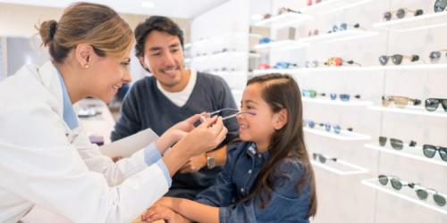 Una niña se prueba unos anteojos junto a su padre.