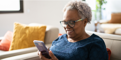 A senior black woman looking at her phone.