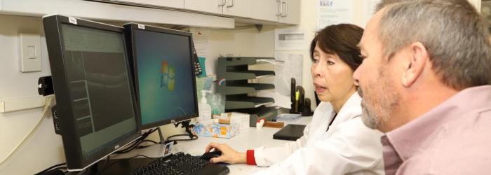 Una doctora le muestra a un paciente un escaneo de retina.