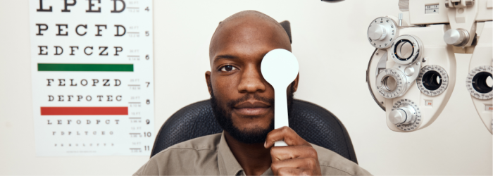 A man holds an occluder over his left eye.