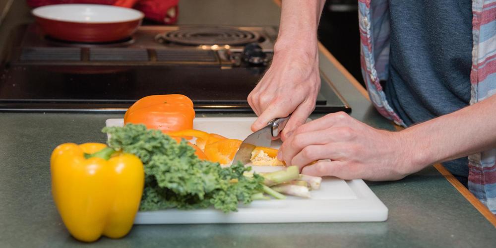 A person cuts up a bell pepper.
