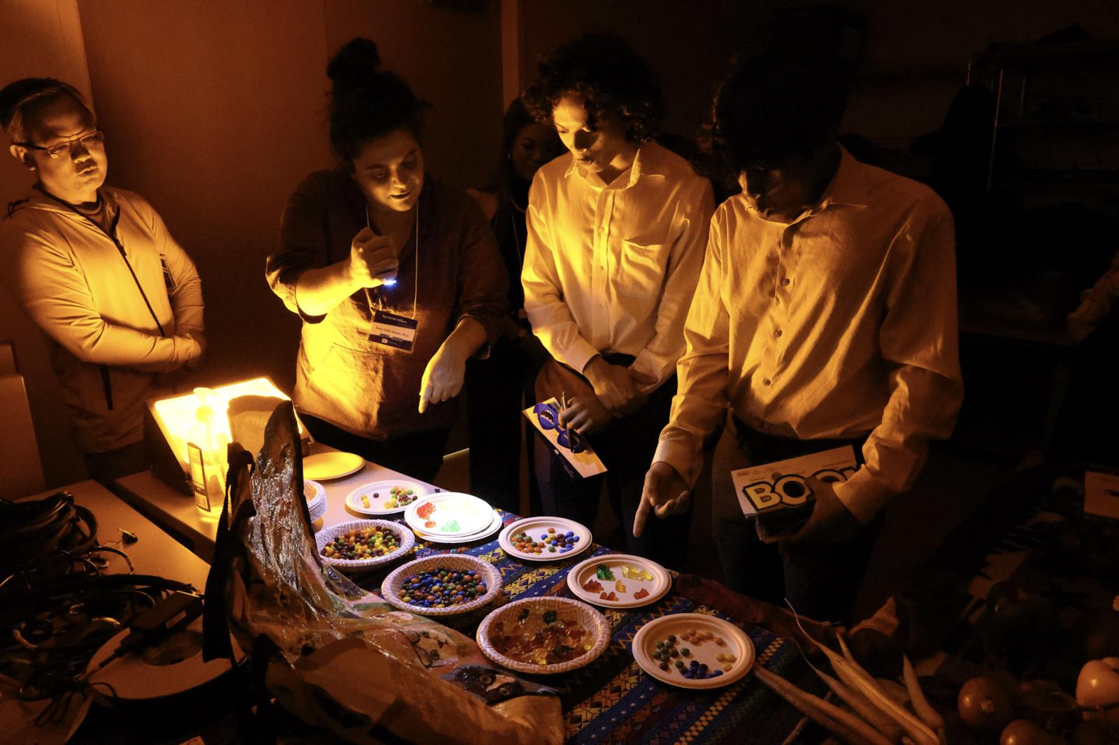 Students examine candies in a yellow room.