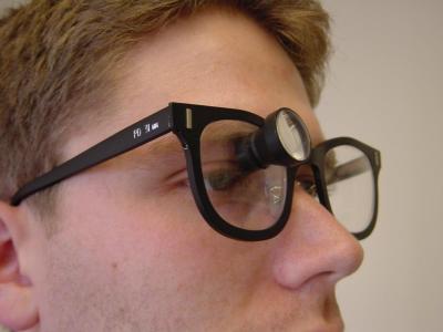 Man wearing glasses with magnifier over one eye