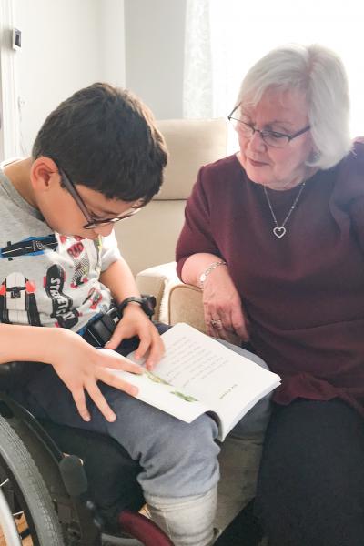 Woman assisting boy as he reads
