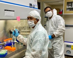 Researchers in protective gear in the laboratory