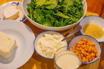 Greens, beans and dairy products arranged on a table