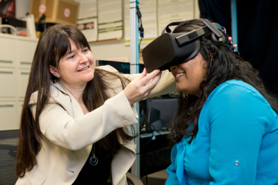 Researcher assists research participant with VR device