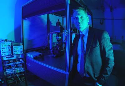 Spencer Smith with microscope in laboratory