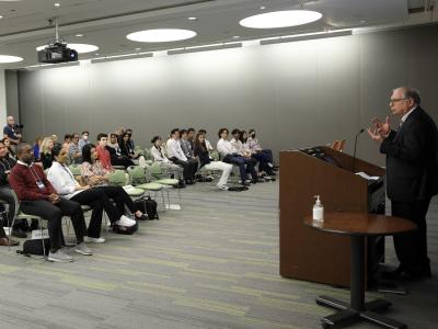 Lawrence Tabak stands at a podium, addressing students