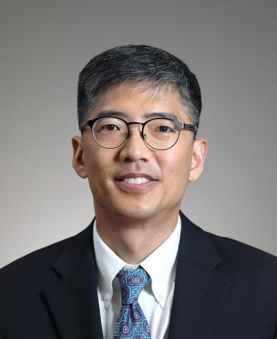 Middle-aged Asian man using glasses, a black jacket and blue tie