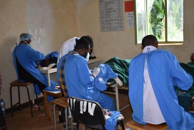 Three surgeons conducting eye surgery in a small room.