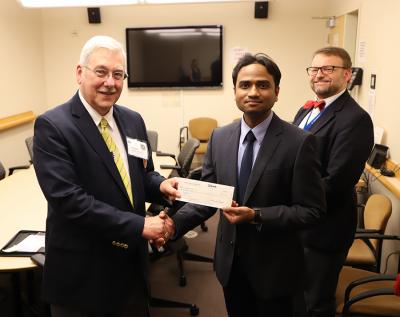 James Golladay and Aman George hold up grant award check