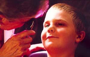 Young boy gets eye exam. 