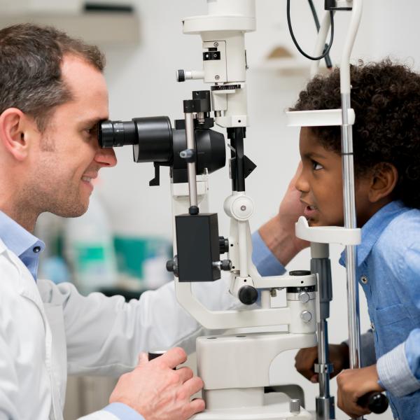 Young boy gets his eyes examined by a doctor