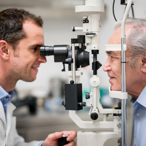 Elderly man has his eyes examined by a doctor