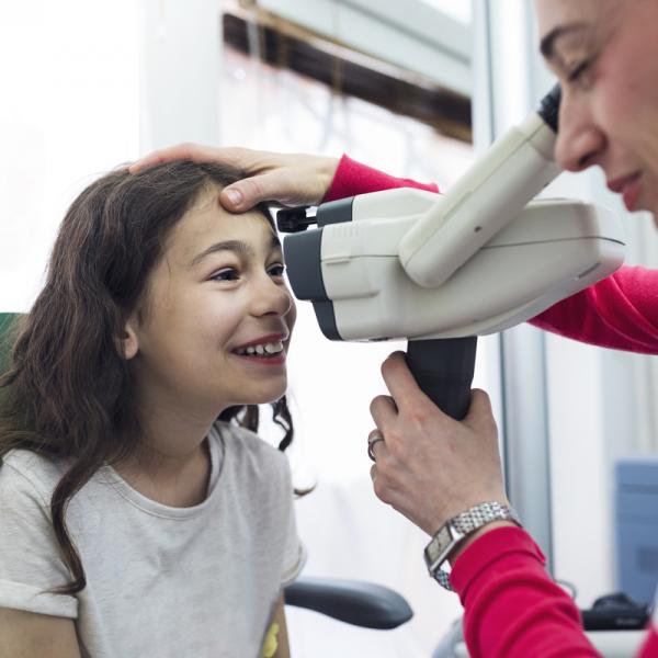 Una niña recibe un examen ocula.