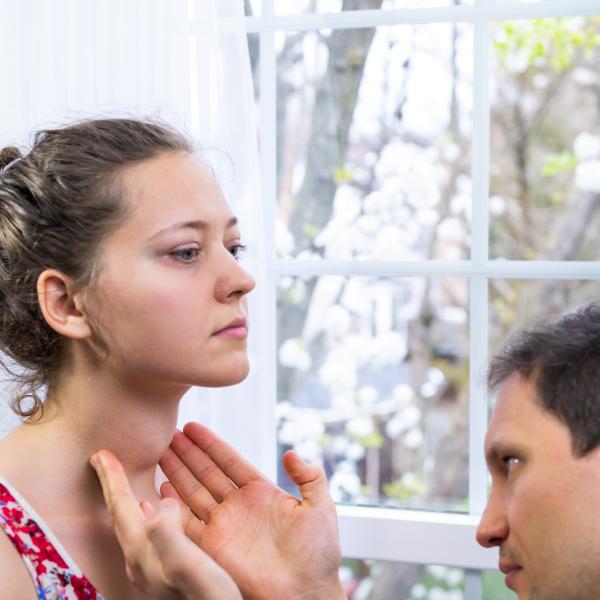 Doctor examines a patient's thyroid.