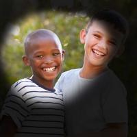 Two boys smile at camera. The outer portion of the image is darkened, representing vision loss from glaucoma.