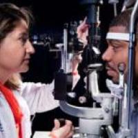 African American male patient gets eye exam from doctor