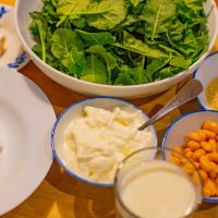 Greens, beans and dairy products arranged on a table