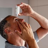 Man applies glaucoma medicine eye drops