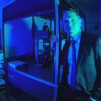 Spencer Smith with microscope in laboratory
