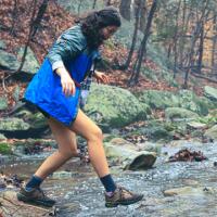 Woman crossing a stream in the woods