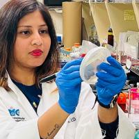 Scientists with plate of bacteria
