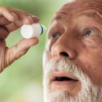 Man using eye drops