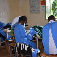 Three surgeons conducting eye surgery in a small room.