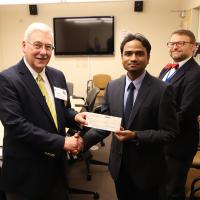 James Golladay and Aman George hold up grant award check